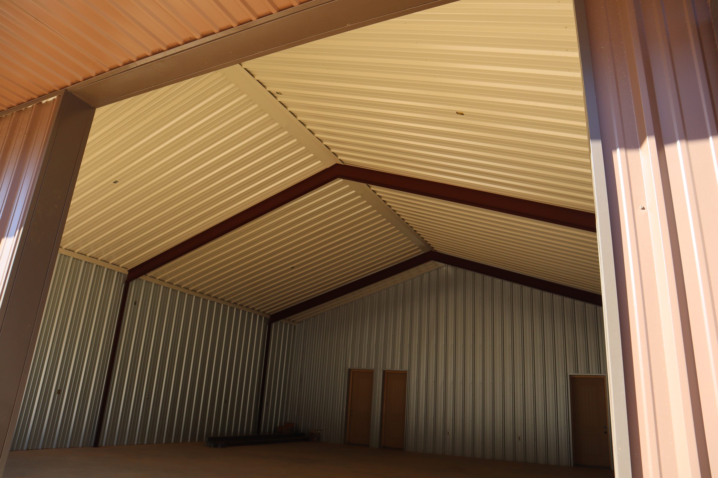 Interior view of a steel building roof showing the contrast between the exterior color coating and interior liner panel