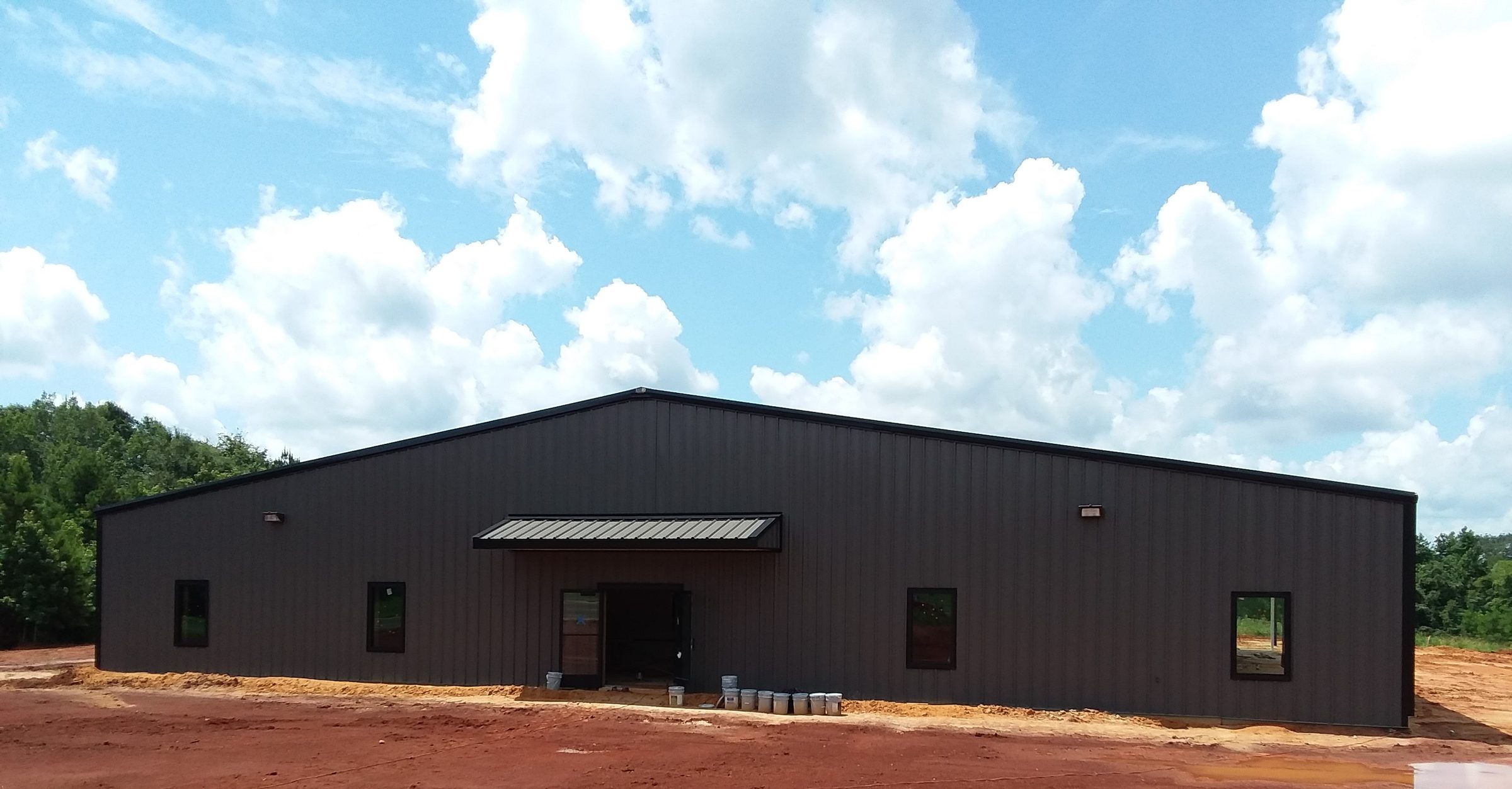 Commercial metal building with matching dark-trimmed windows and an awning entrance