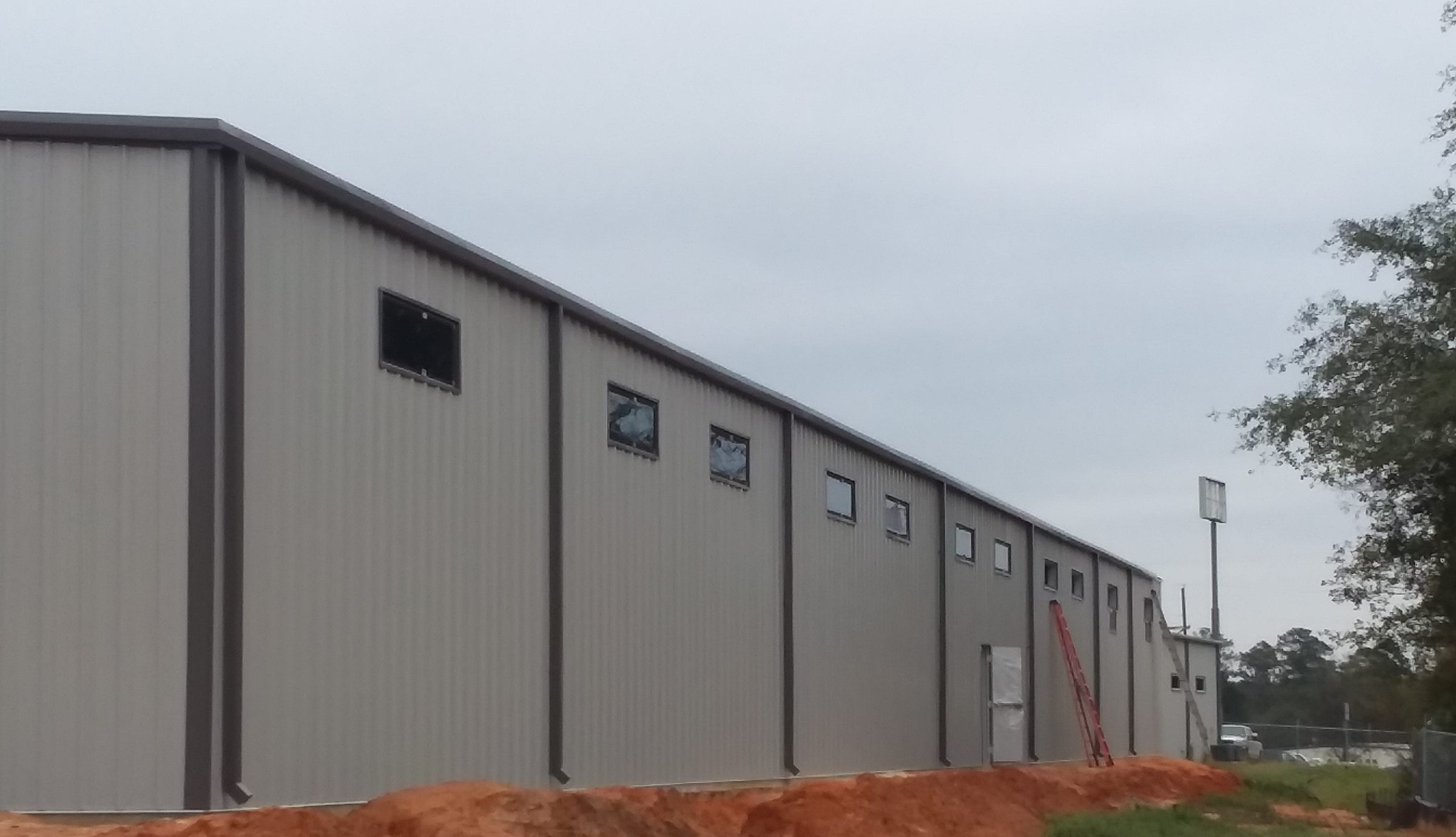 Steel building exterior with several vinyl windows installed at varying sizes